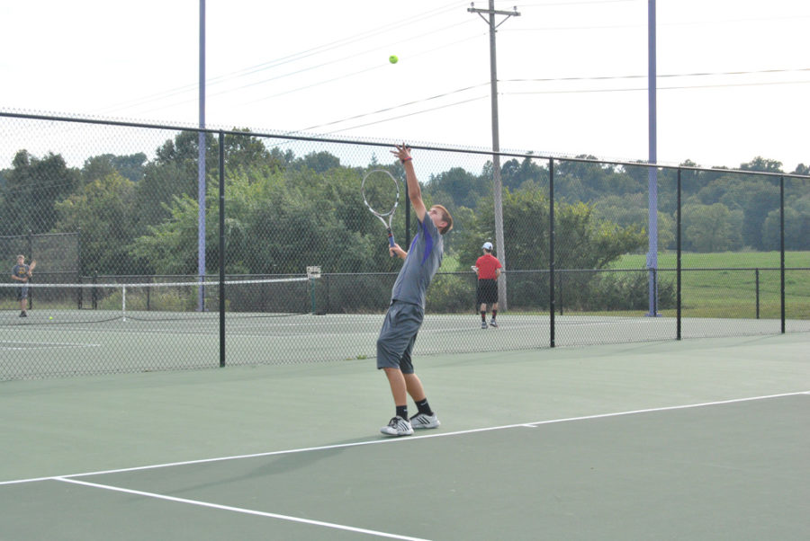 Junior+Michael+Fullington+tosses+up+the+tennis+ball+to+practice+his+serve.