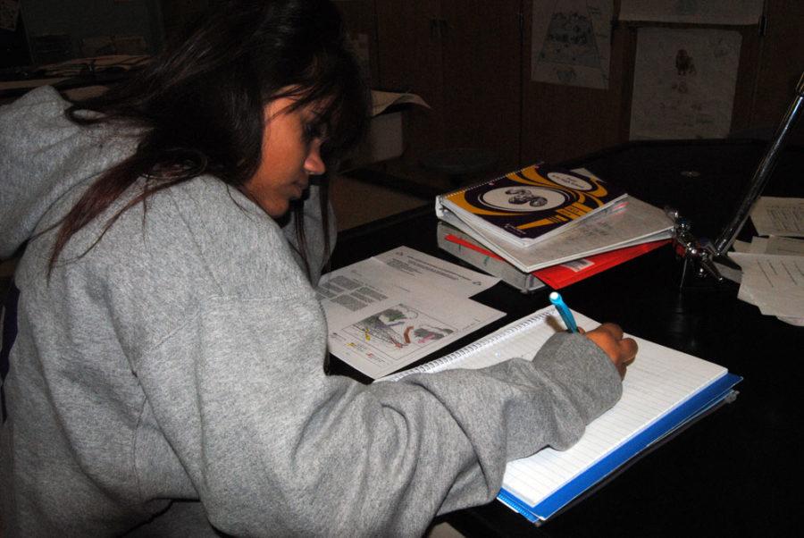 Freshman India Wong works on homework in Melissa Higgins biology class.