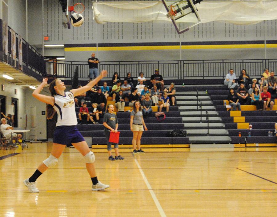 Eighth grader Anna Hutcheson tosses up the ball to serve.