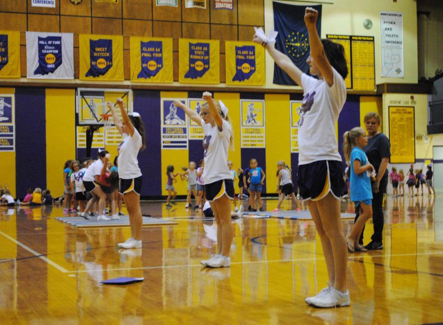 Sophomore Alyssa Blythe, senior Zoe Dyer, and junior Alyx Ross practice a cheer.