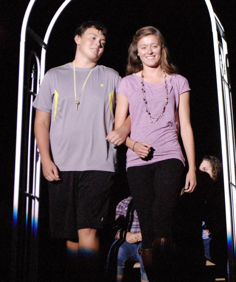 Junior Morgan Kingston escorts her brother, sophomore Brandon Kingston, to his seat at the NHS tapping.