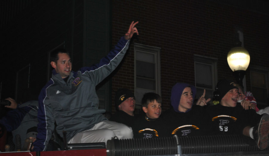 Coach Matt Holcomb celebrates with the team as they return from the sectional championship game.