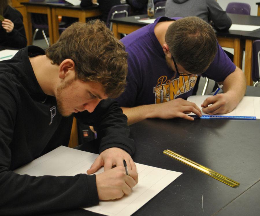 Seniors Dylan Lowe and Lee Apple concentrate closely on their 1st period art projects.