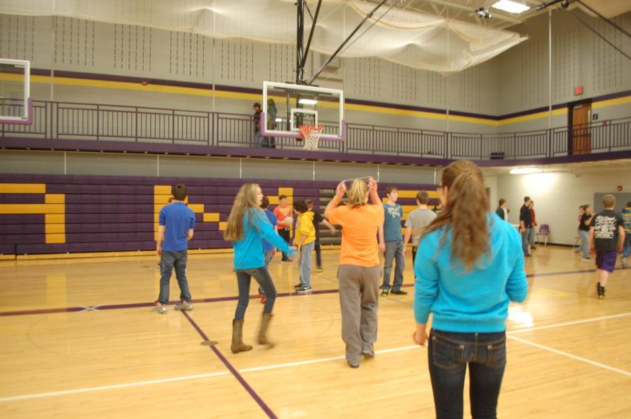 A group of junior high boys and girls play volleyball and basketball during junior high lunch/recess in the auxiliary gym. 