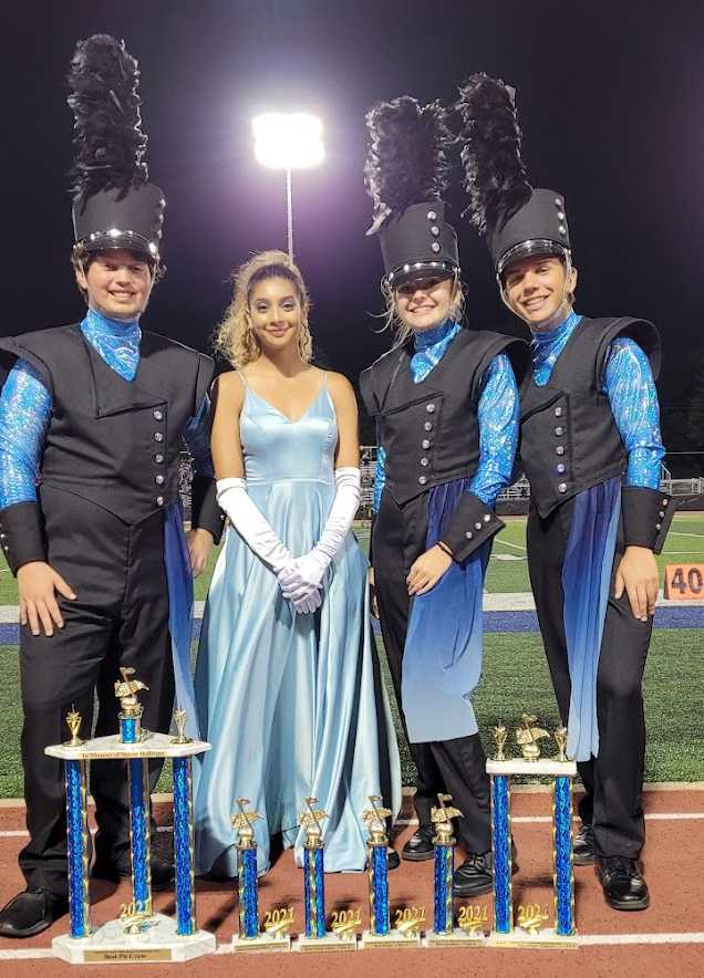 Seniors Elijah MacDonald, Angie Ceja, Kylee Charles, and Michael Hannon pose in front of the trophies they won at a competition at Columbus High School