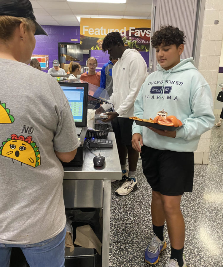 Freshman Dominic Garcia checks out in the lunch line after getting his lunch from Oppa!