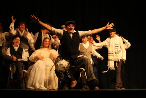Senior Adin Monroe as Tevye dances at the front of the stage in celebration of the wedding of his daughter Tzeitel and Motel.