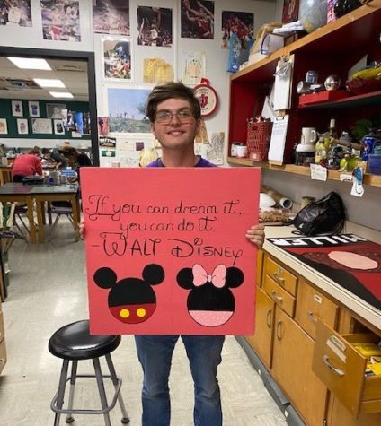Senior Dawson Poe poses with his painted ceiling tile, which features Micky and Minnie Mouse.