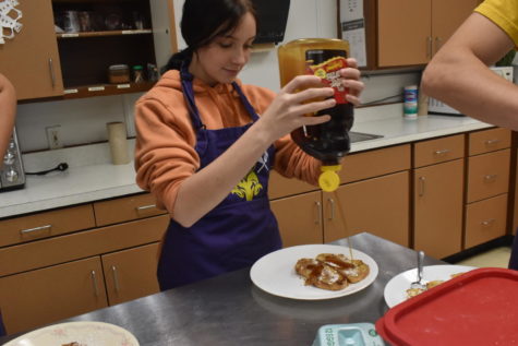 Junior Ruby Chesnut adds syrup to her food.