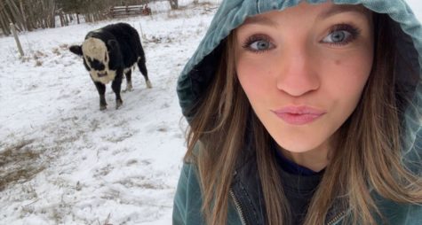 Senior Lara Brace poses with her cow during the winter season.
