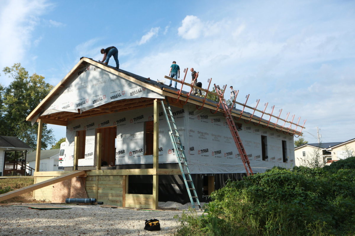 Members of the construction class work on the roof of the house on Cherry Street.