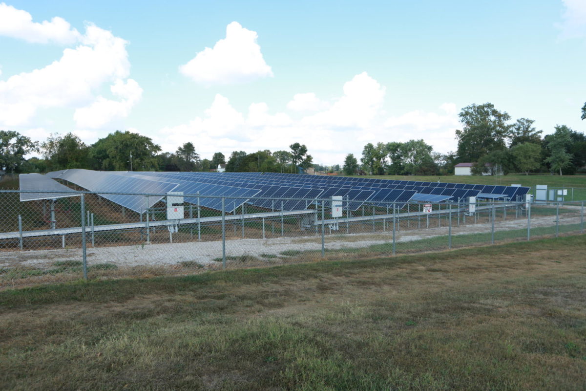 Solar panels outside Orleans High School, installed in 2017, help power the corporation.