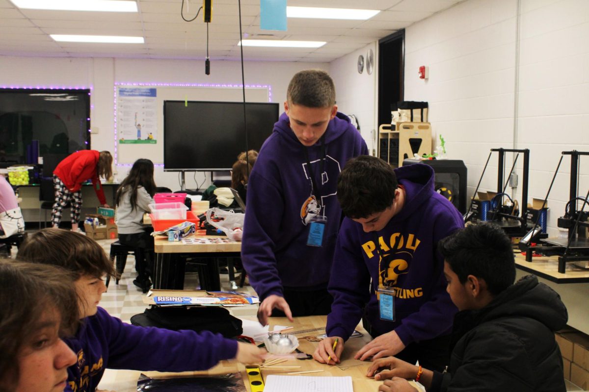 Eighth graders Cooper Lane, Jordan Albertson, and Krish Patel work together to measure and craft their team project.