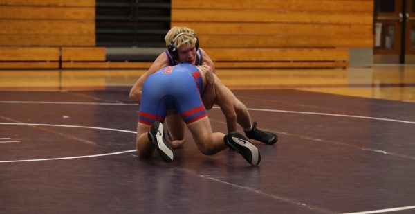 Junior Jonny Shellenberger attempts to pin his opponent during a match.