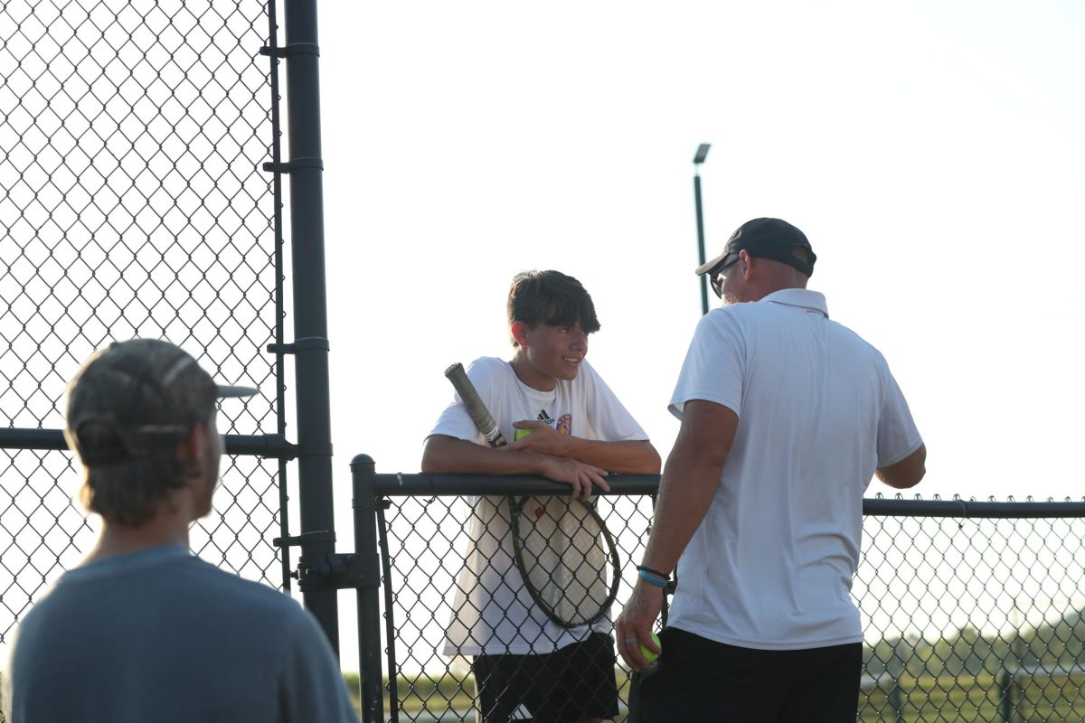 Junior Dakota Mousty talks to coach Matt Wolfe during his match.