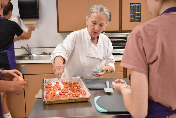 Teacher Debbie Andry, sprinkles salt on the peppers.