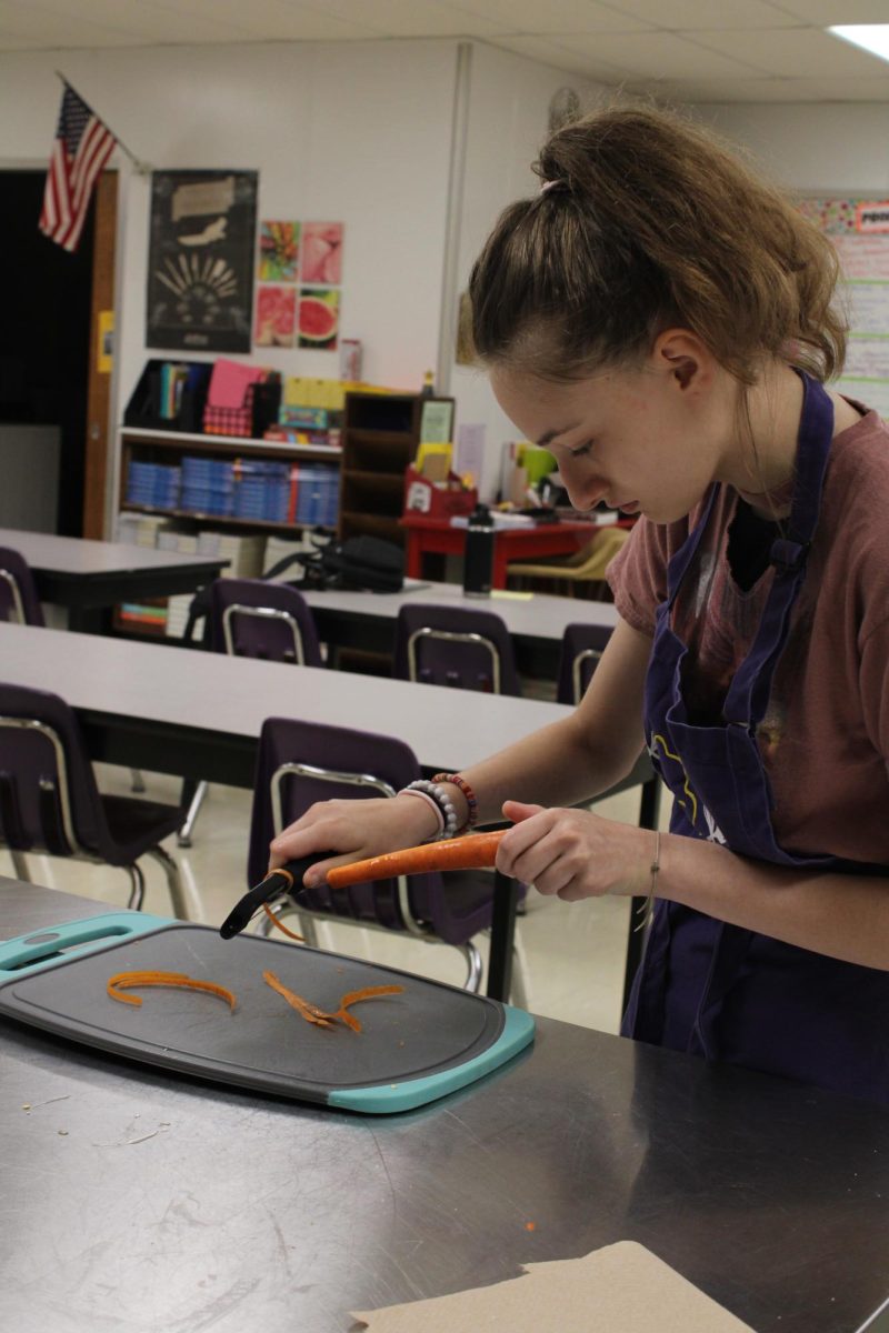 Senior Ellisa Parks carefully peels the skin off of the carrots. 