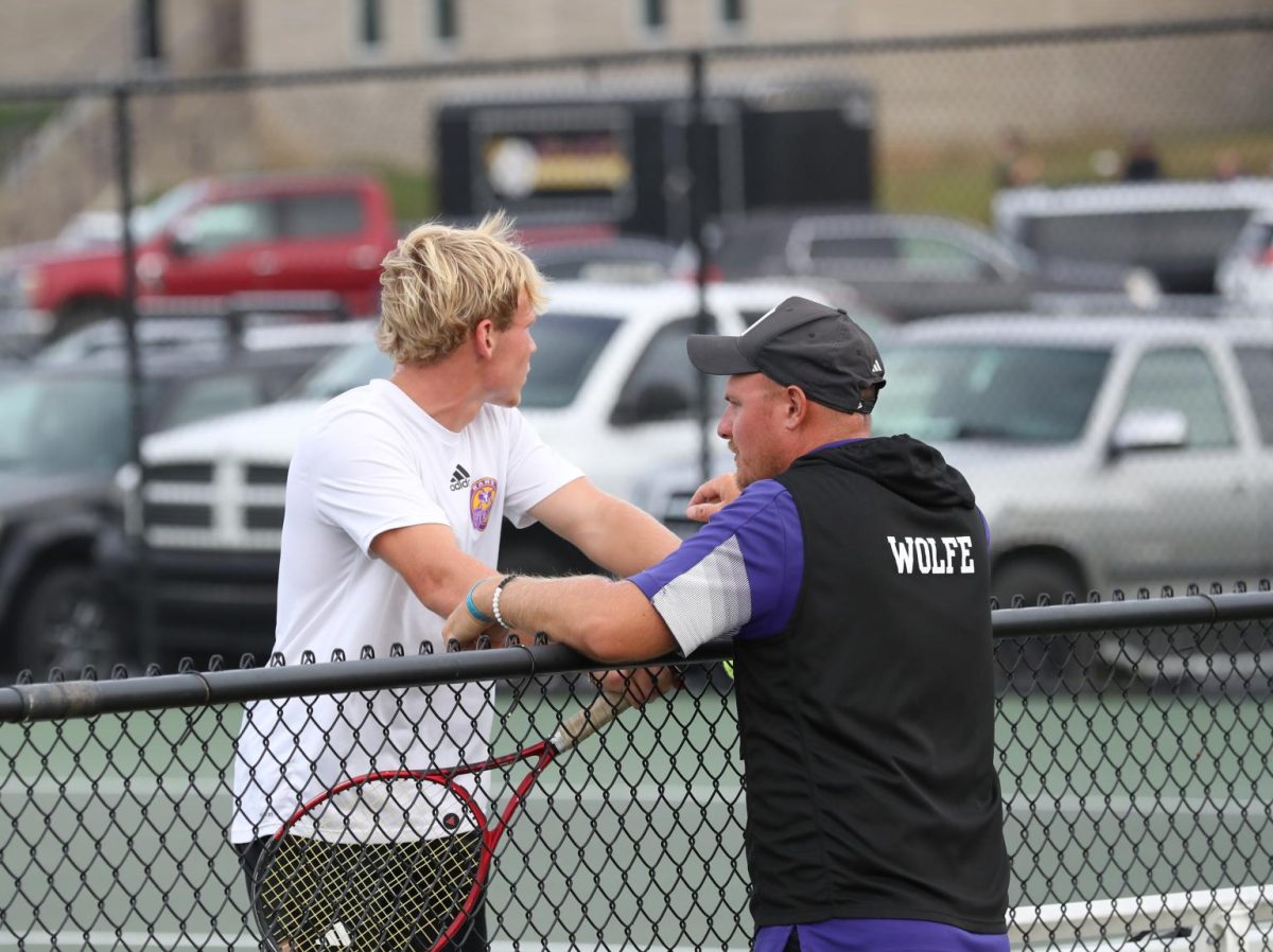 Junior Jonny Shellenburger and Coach Matt Wolfe talk in between sets.