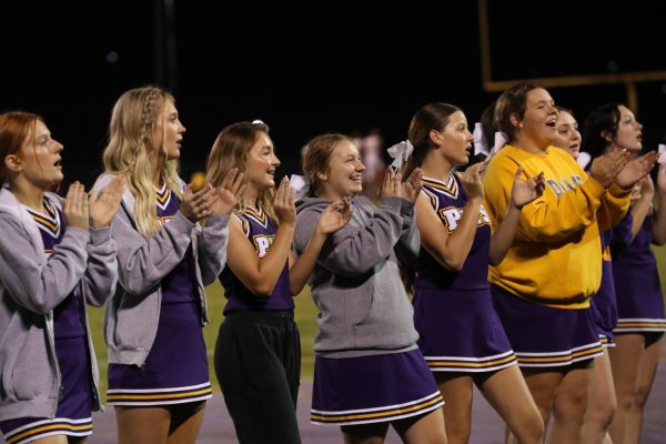 Senior Cheer Squad Captains Taylor Patton and Chloe Smith (pictured middle) celebrate a win after a football game.