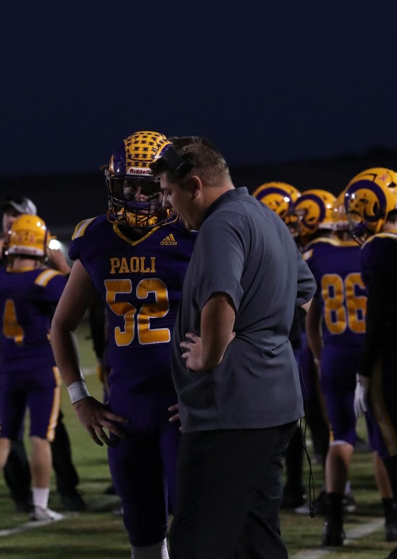 Senior Jaxson Reynolds talks strategy with Coach Garrett Sanders.