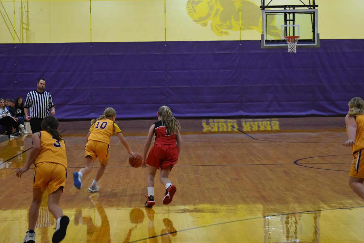 Sixth Grader Eliza Brown brings the ball down the court.
