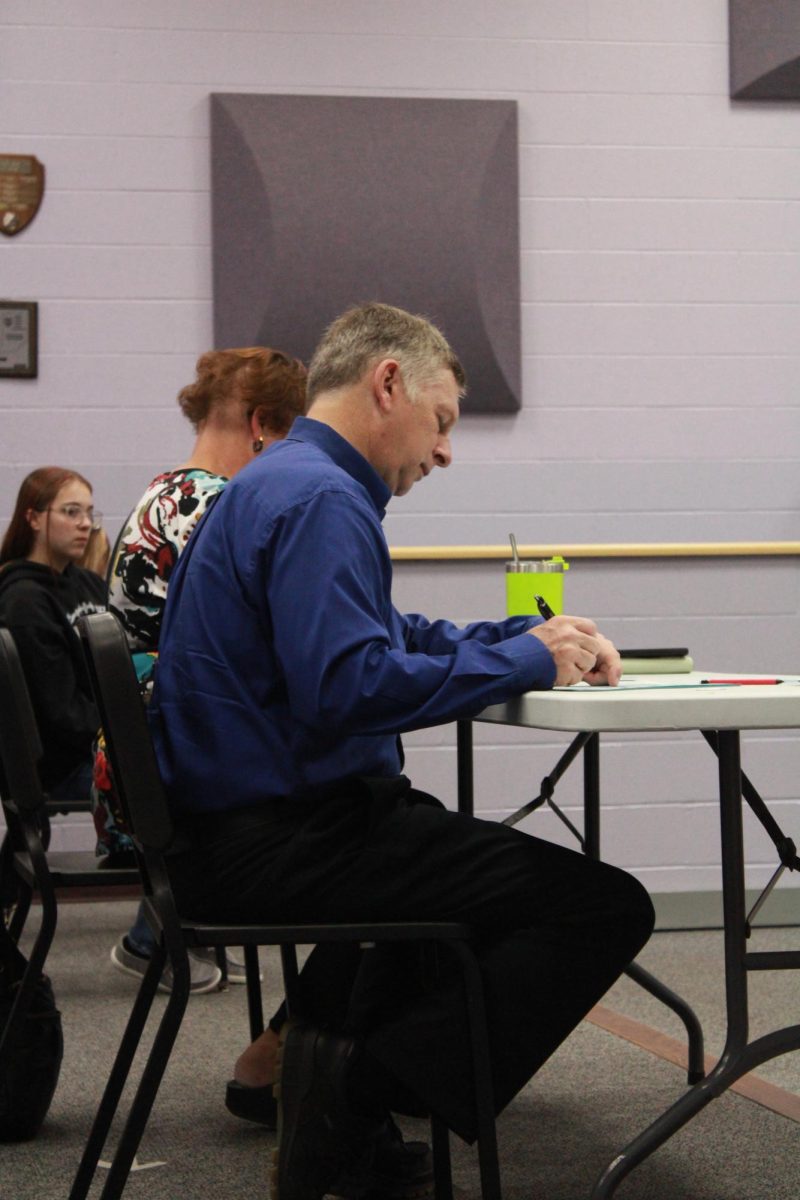 Judges filing out their papers to grade the contestants in the category of contemporary poems.