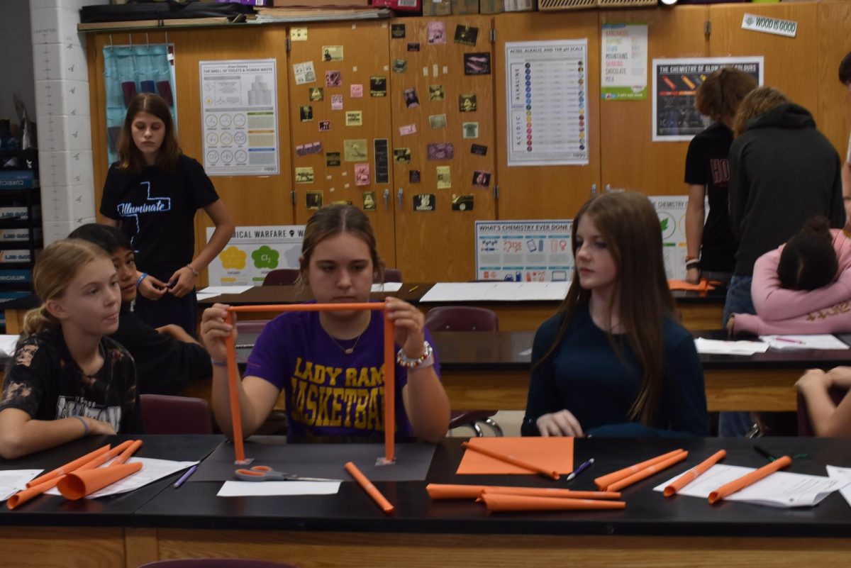 Eighth Grader Charlee Ashley holds her model in place. 
