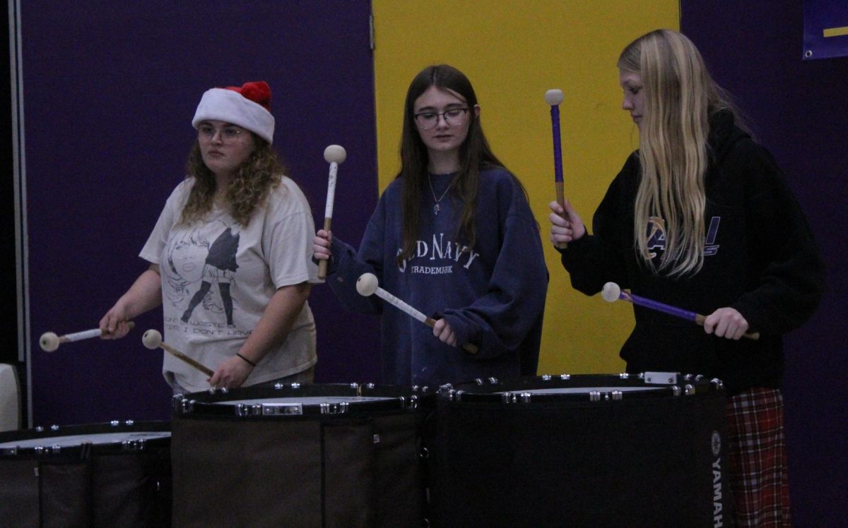 Senior Lainee Cox and freshman Carleigh Porter and Sunday Asbell playing their drums.