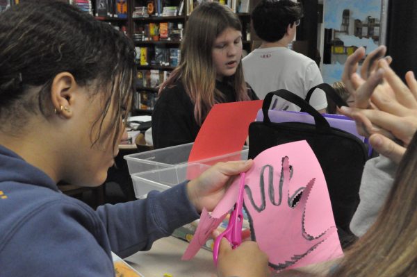 Eighth Grader Ivy Gilbert cutting around her Hand Turkey.