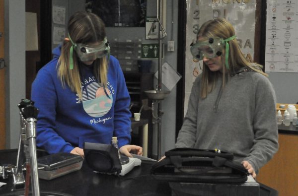 Junior Abby Poe, and Sophomore Allison Livingston look at their beaker. 