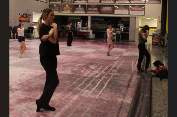 Ava Middleton leads stretches for the PHS winter guard during practice.