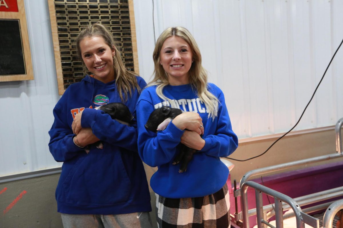 Seniors Jerzie Crane and Makynsie Russelburg holding the baby pigs