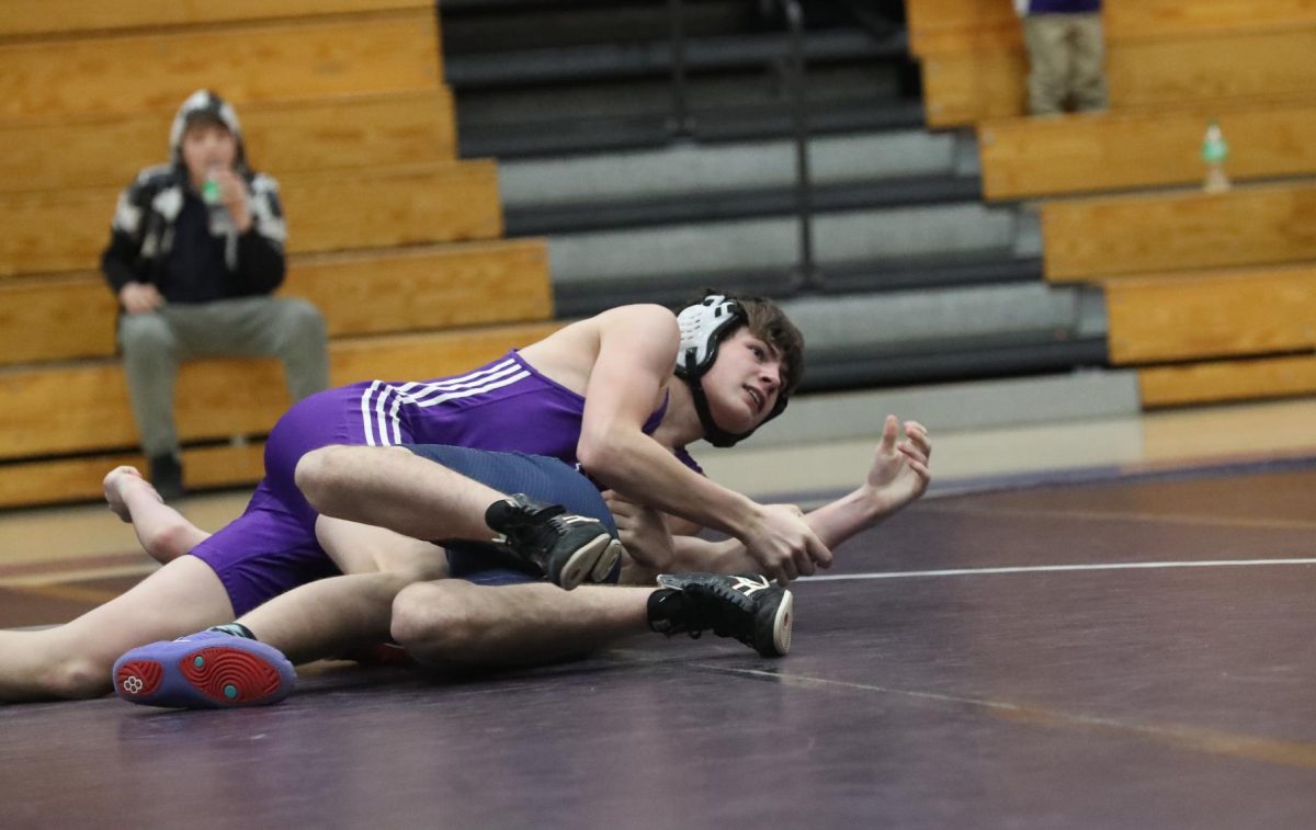 Eighth grader Derrick Albertson pins his opponent