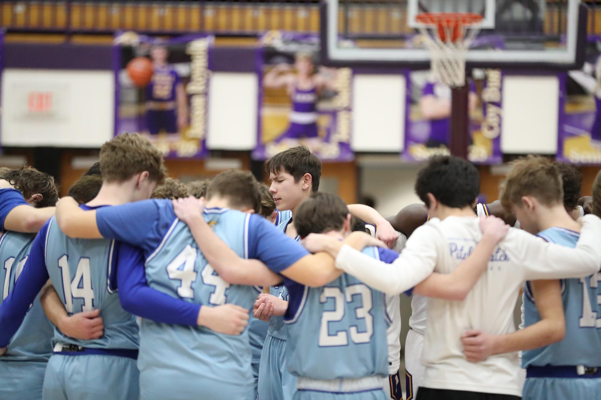 Rams pray with the Warriors after game.