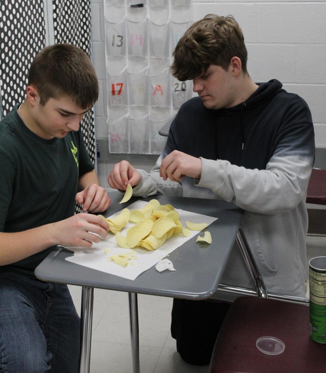 Sophomores Graydan Padgett and Joe McDonald help each other to build their Pi day pringles project.