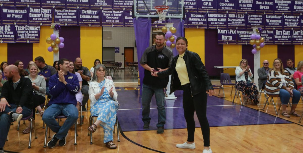 Senior Jericho Hopper hands a Rammy award to Algebra 1 teacher Aaron Key.