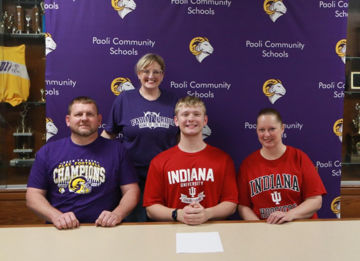 Senior Coy Busick poses with his parents Angie and Mike Busick and his high school coach, Heather Nichols. 