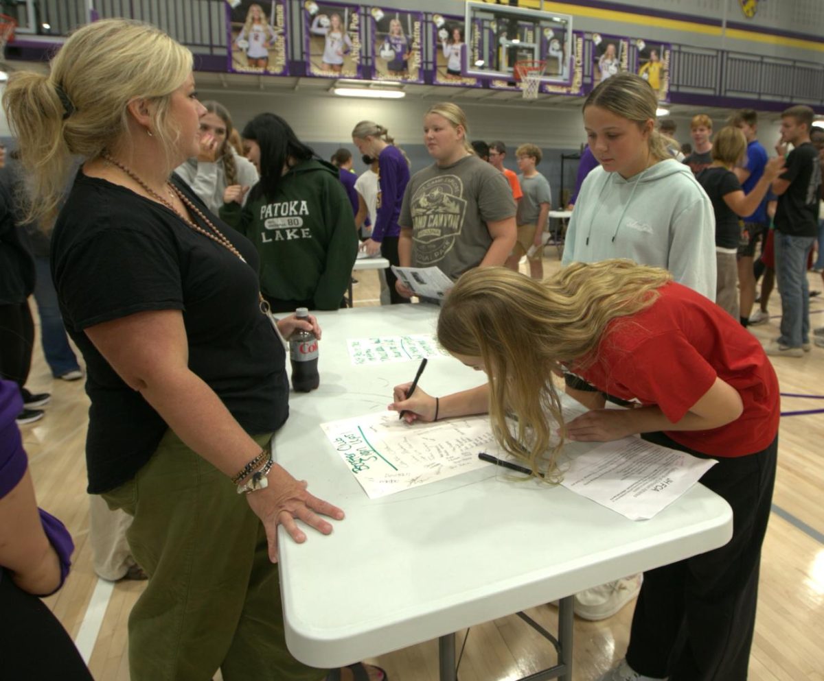 Students sign up for Booster Club at the display booth. Alexis Speer is the new Booster Club sponsor for this year.
