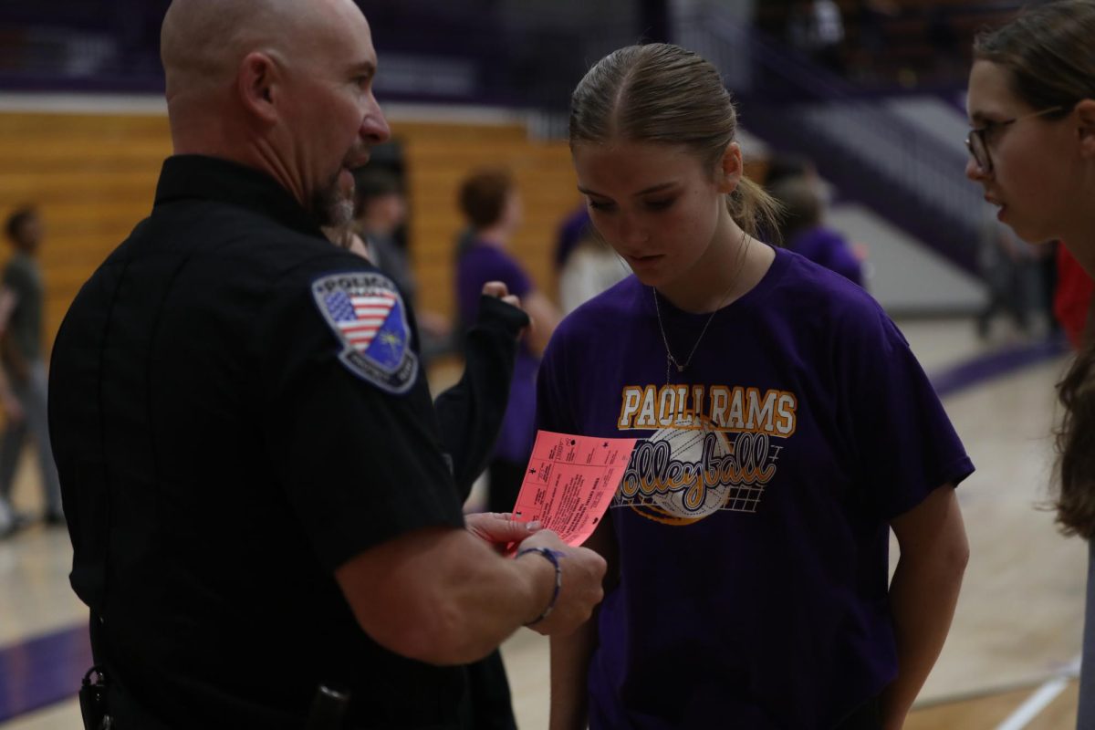 SRO John Deaton stamps the paper for Sophomore Bailey Tyler.