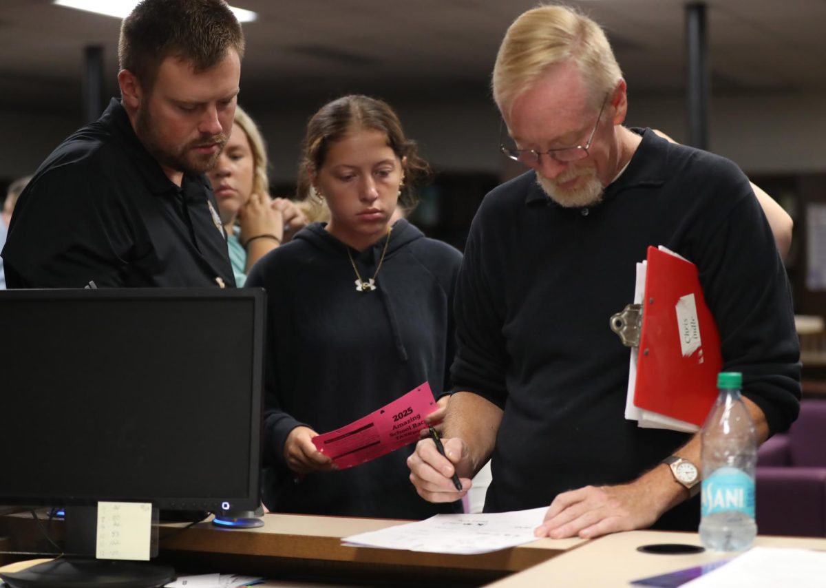 Chris Lindley checks Aaron Key's homeroom's paper for the Amazing Race. Results of the Amazing Race earn each class points for the class cup.