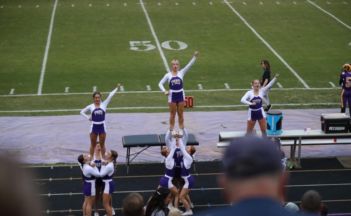 The cheer squad show off a stunt.