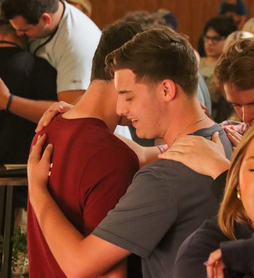 Cannon Lambdin prays with a fellow student.