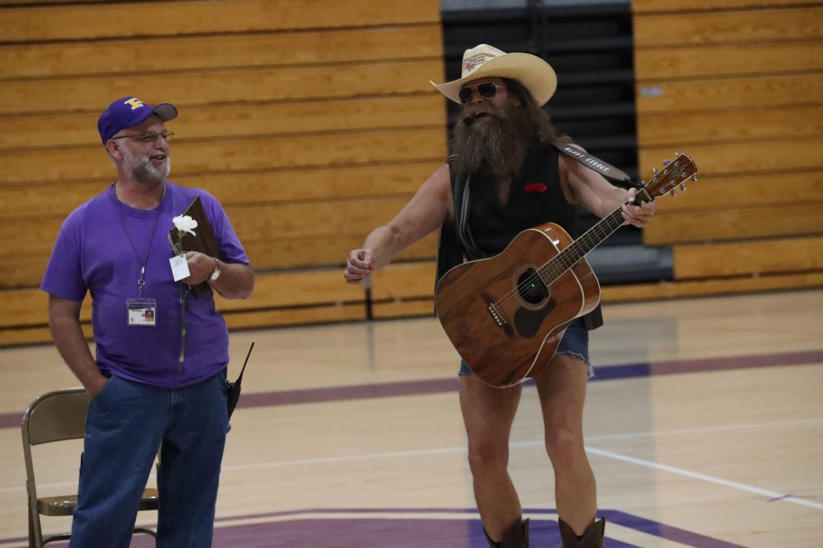 Kevin Moon smiles as Happy George sings him a farewell song at his retirement event.