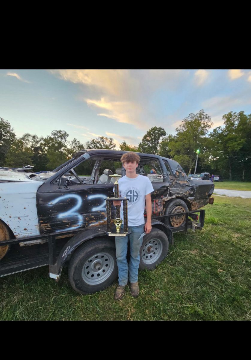 Sophomore Weston Elliott poses with his first demo car and trophy. 