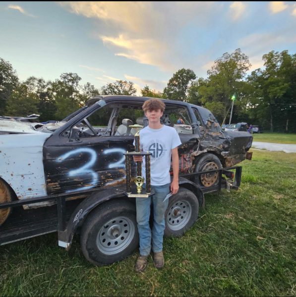 Sophomore Weston Elliott poses with his first demo car and trophy. 