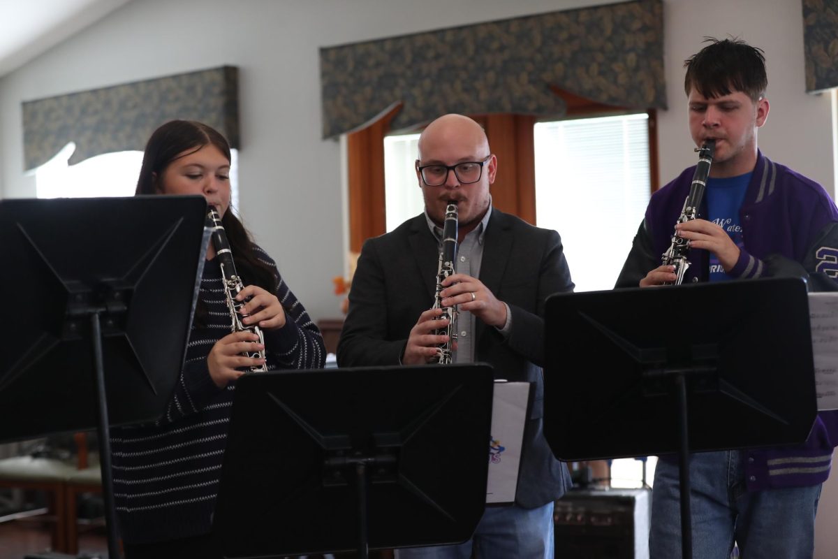 Band Director Christian Karkosky, Freshman Lillian Burgess, and Junior Joshua Young play the clarinet for the residents at the nursing home.