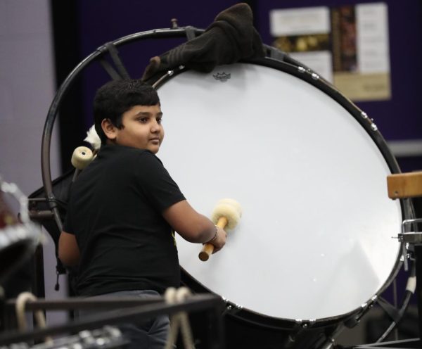 7th grader Sneh Patel hits the drum. 
