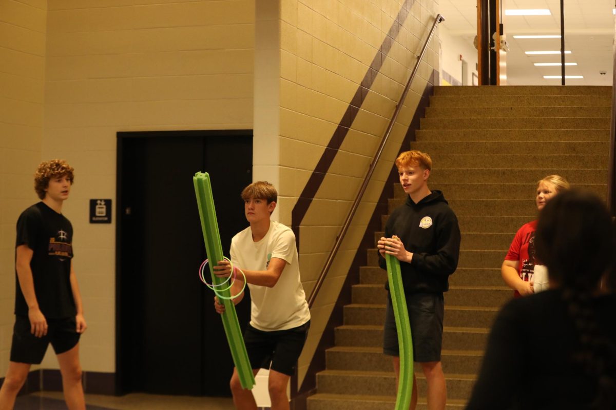 Freshman Tripp Spencer attempts to catch rings on a pool noodle.
