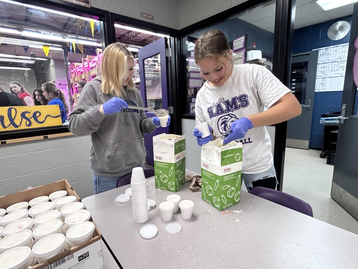 Seniors Alissa Henry and Cherokee Hopper package meals for the FFA project.