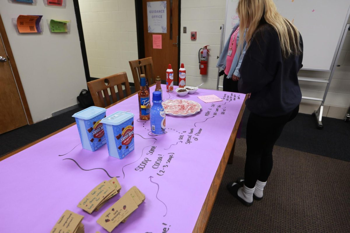 Senior Jesslyn Brown writes Hot cocoa instructions on the table.